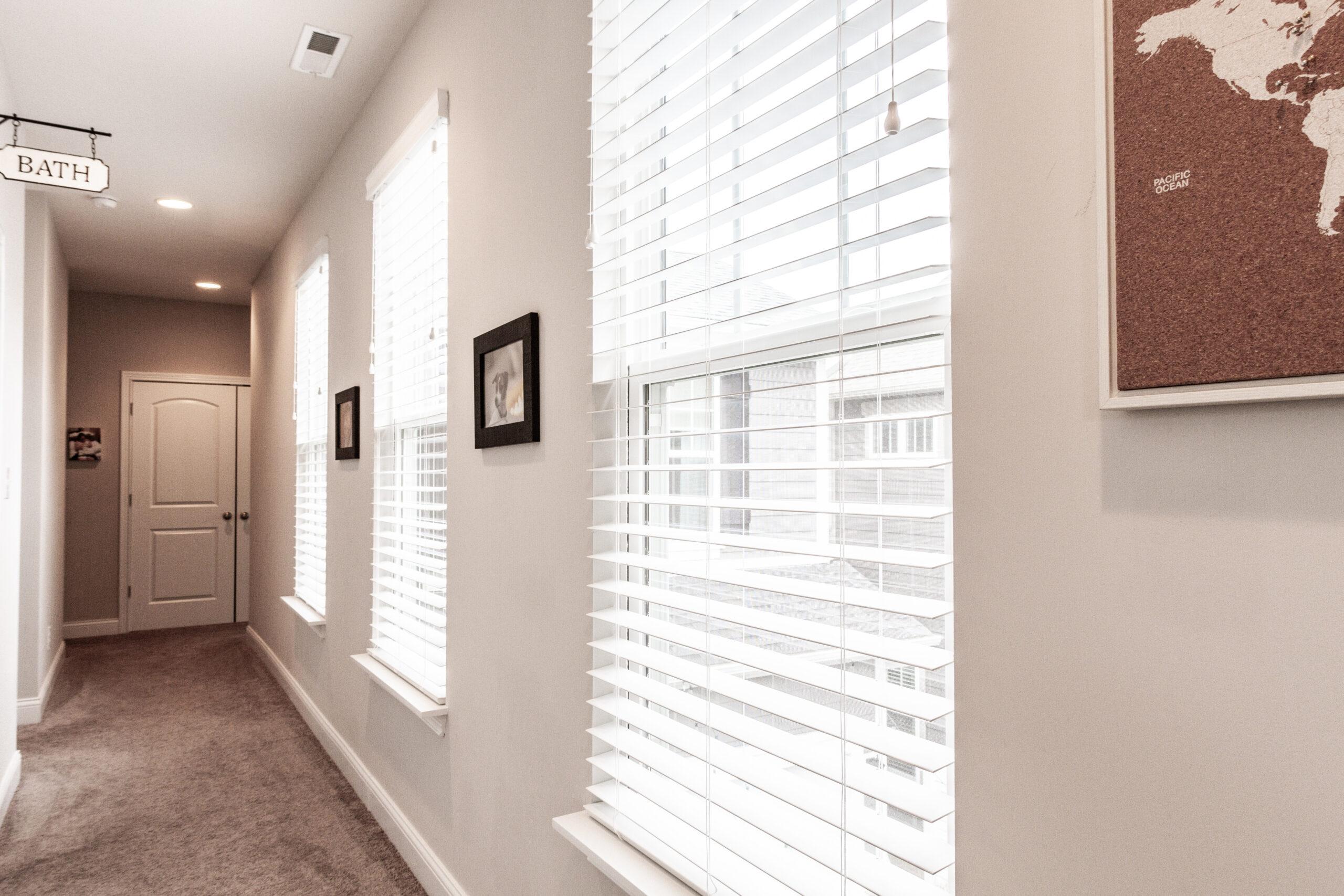 A hallway with white walls and wooden floors.