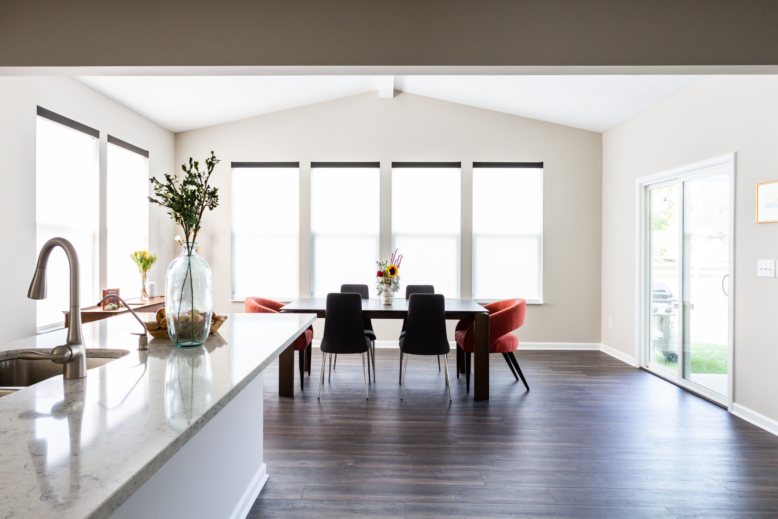 A dining room with a table and chairs, and a large window.