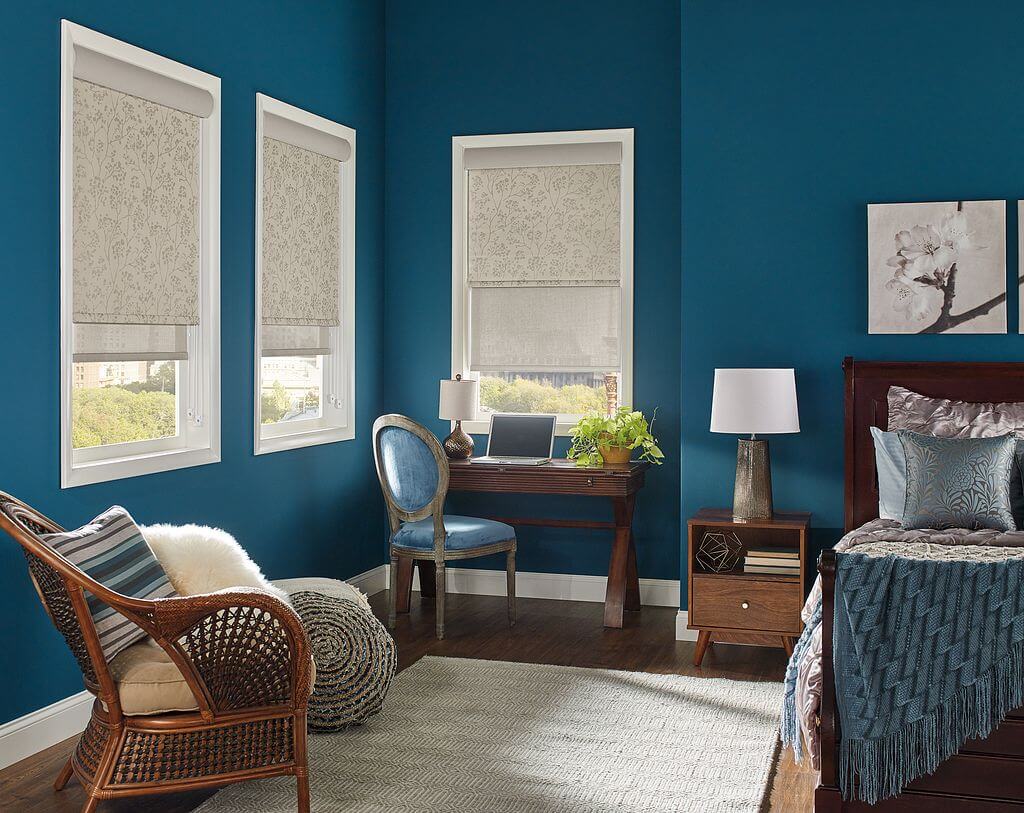 A bedroom with blue walls and furniture.