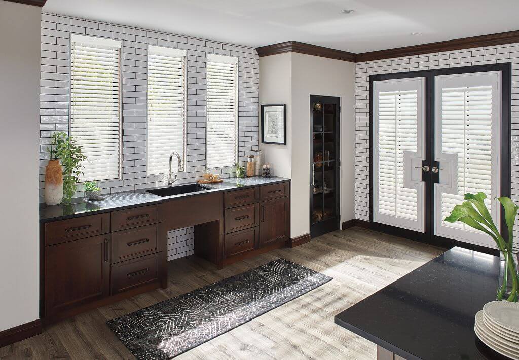 A kitchen with white walls and wooden cabinets.