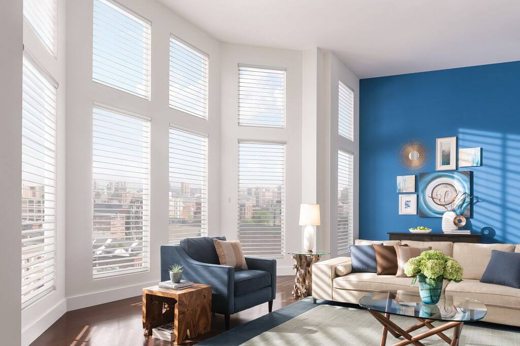 A living room with large windows and blue walls.