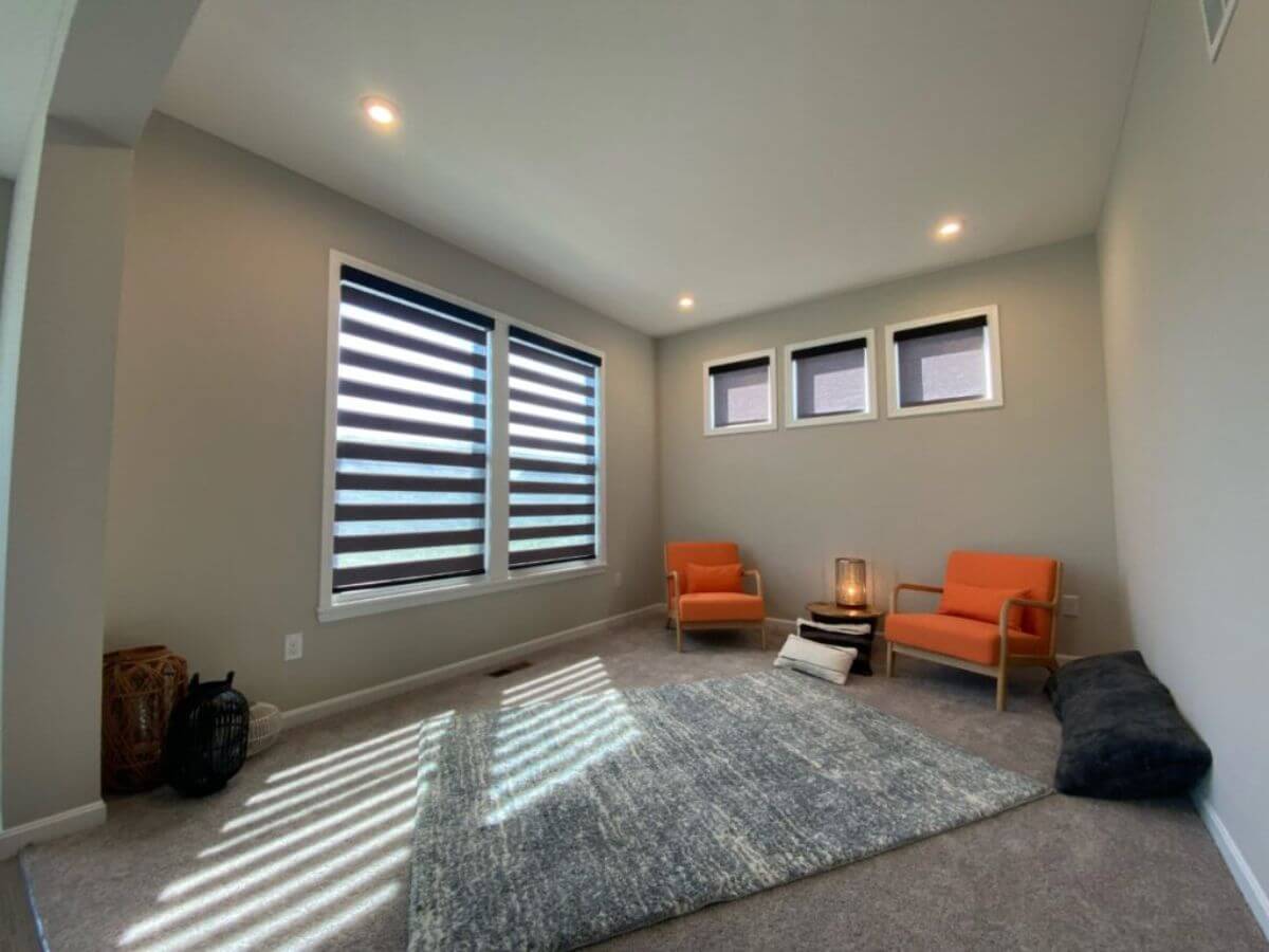 A living room with two orange chairs and a rug.