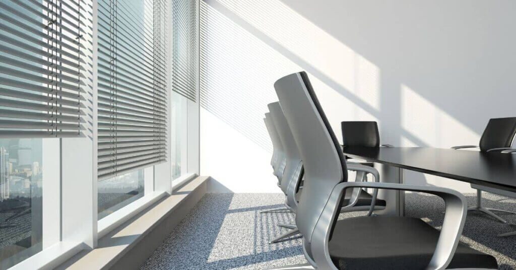 A conference room with chairs and tables in front of the window.