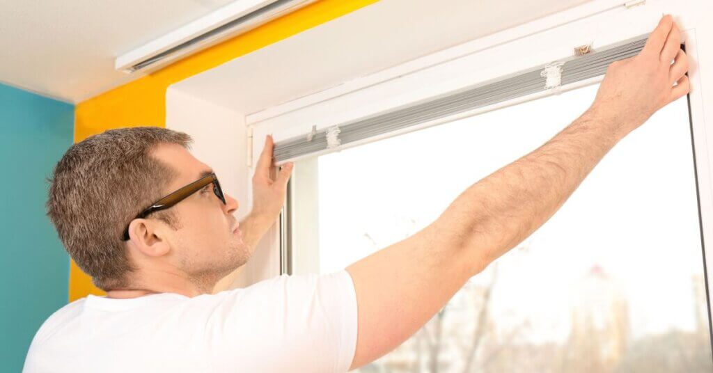 A man is fixing the window on a bus.