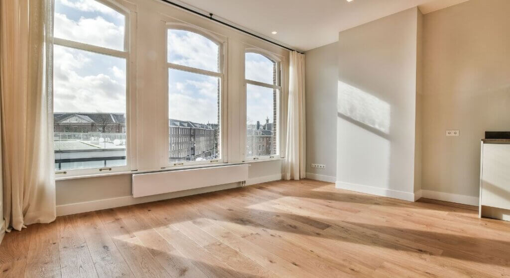 A room with many windows and wooden floors