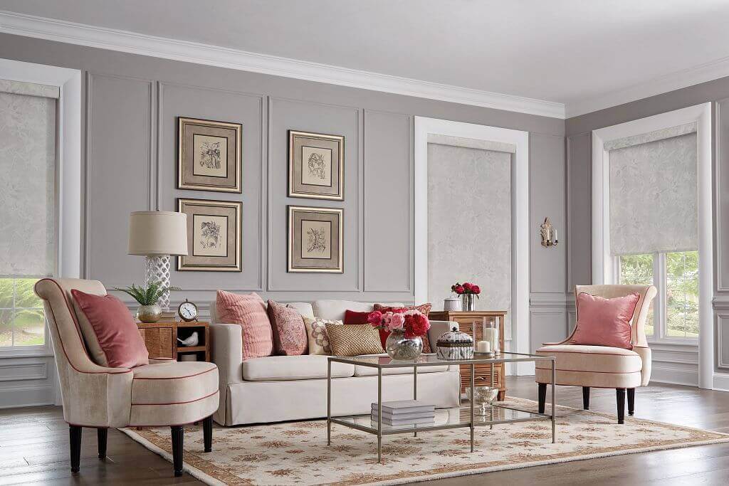 A living room with two pink chairs and a white couch