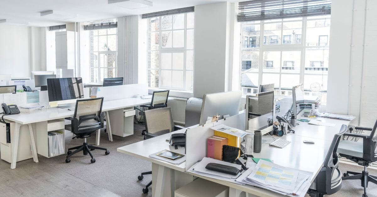 A large open office with many desks and chairs.