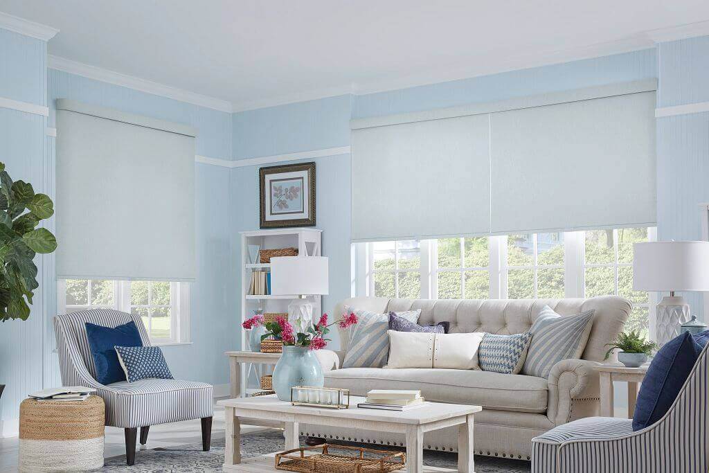 A living room with blue walls and white furniture.