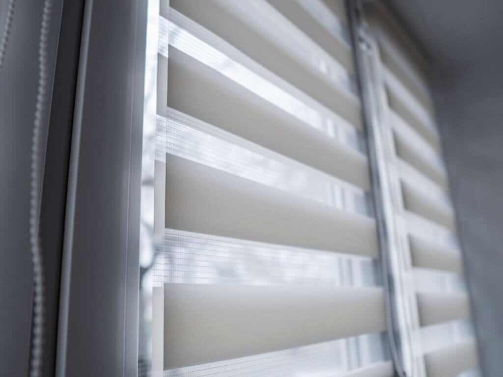 A window with blinds that are closed and open.