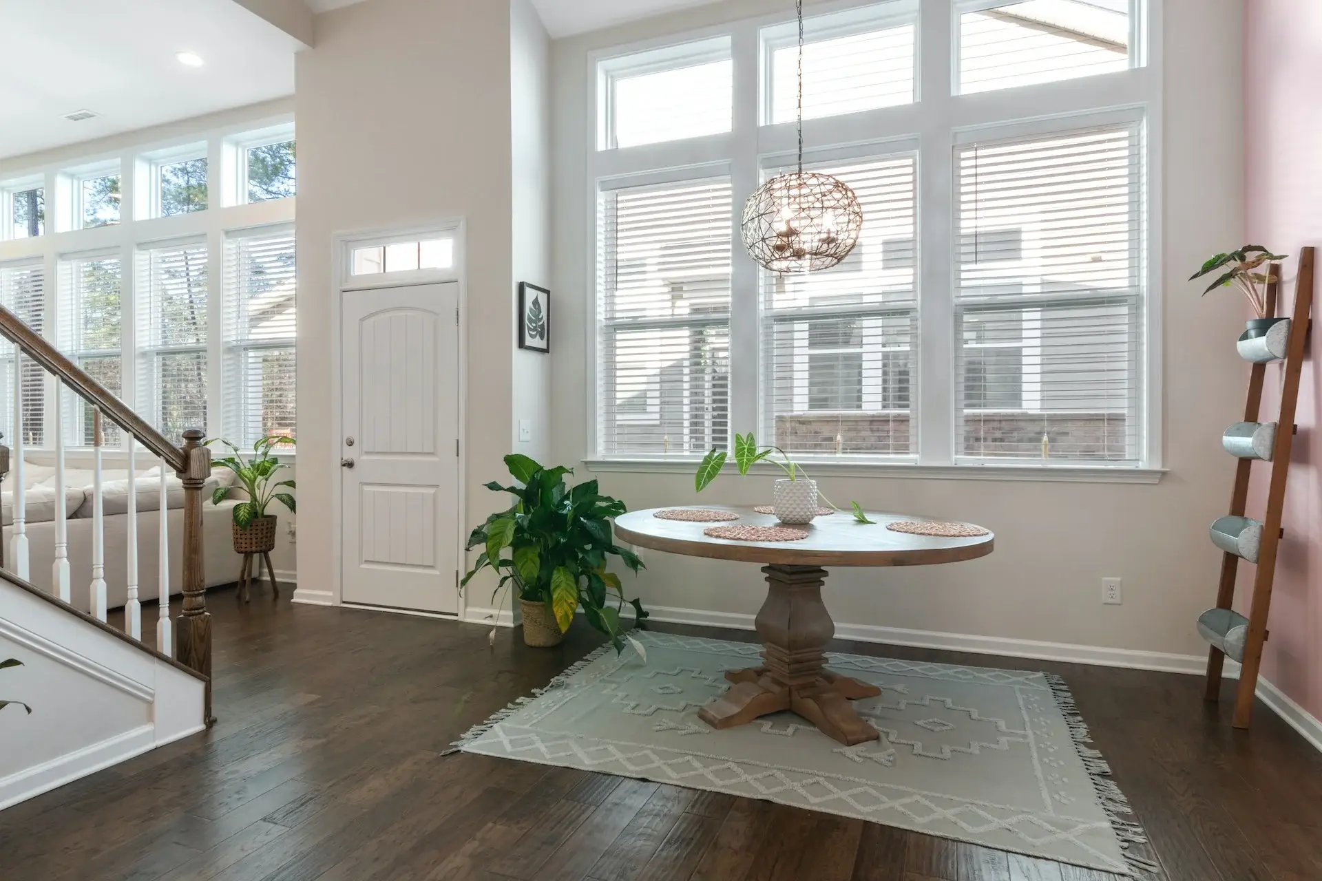 A white table and chairs in front of windows.