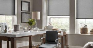 A chair in front of a desk with a lamp and window.