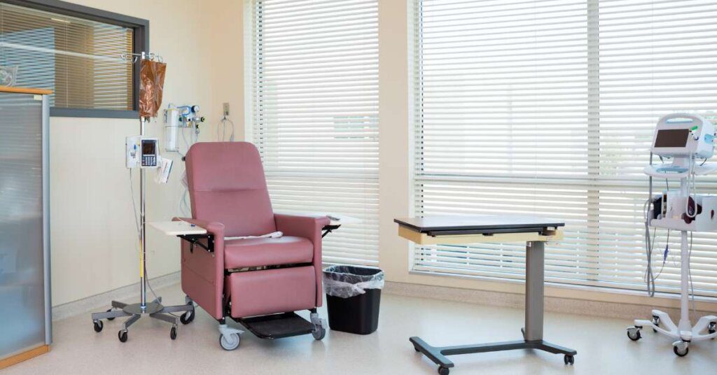 A hospital room with a chair and table.